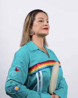 Portrait of woman in profile holding feather and wearing regalia