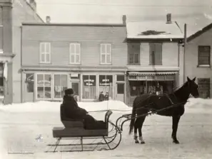 Image of man on horse-drawn sleigh before Charlie Sing laundry