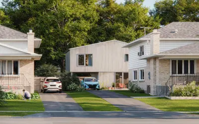 Two-storey coach house with a carport at ground level, set behind a detached home on a residential lot.