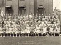 Black and white photo of Dominion Life Assurance Company employees seated and standing in front of office