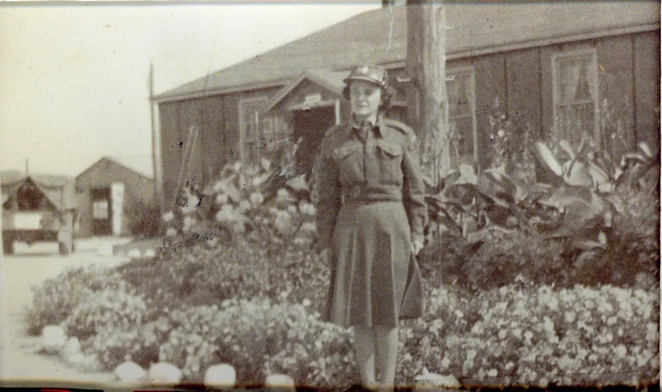 Image of woman in uniform before a garden