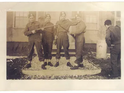 Image of five men in uniform, one with back to camera