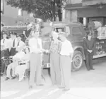 Acting Mayor Waldon Ewald (left) hands keys to Ratz in front of fire truck and station.