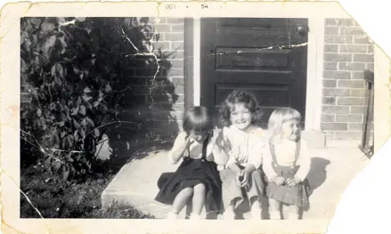 Image of three children sitting on step