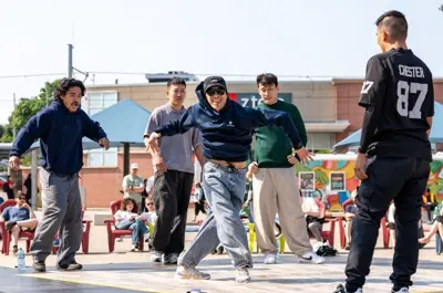 A group of people engaged in a dance battle in Waterloo Public Square, surrounded by onlookers.
