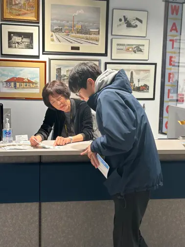 Woman volunteering at the Museum front desk welcoming a resident