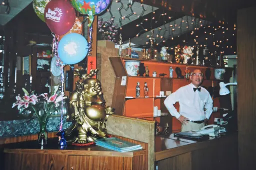 Image of man standing behind counter with balloons
