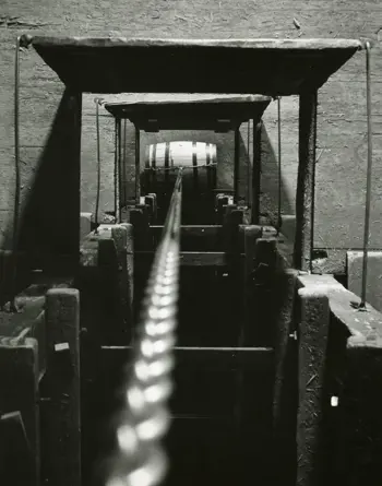 Black and white image of Lowering Barrel Through Trap Door 