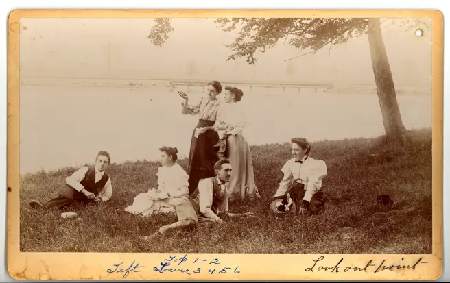 Sepia-toned 1894 photograph of a small group picnic at the lookout point overlooking Silver Lake in Waterloo Park, with tree canopy and lake visible.