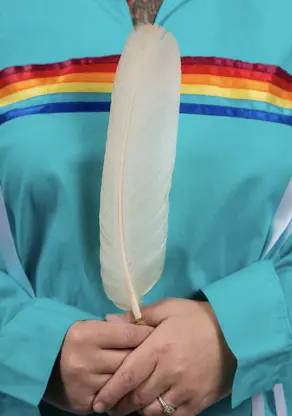 Eagle feather held in-hand.