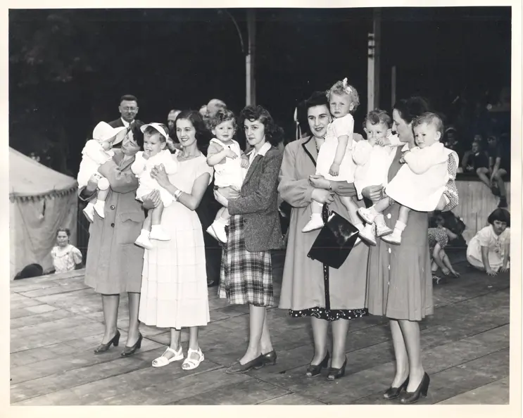 Image of women holding babies on stage