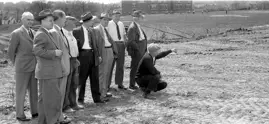 Image of nine men surveying housing site