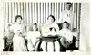 Black and white photo of five family members. Four sitting on couch and one standing behind.