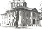 Black and white photo of Waterloo Central School with students walking nearby.