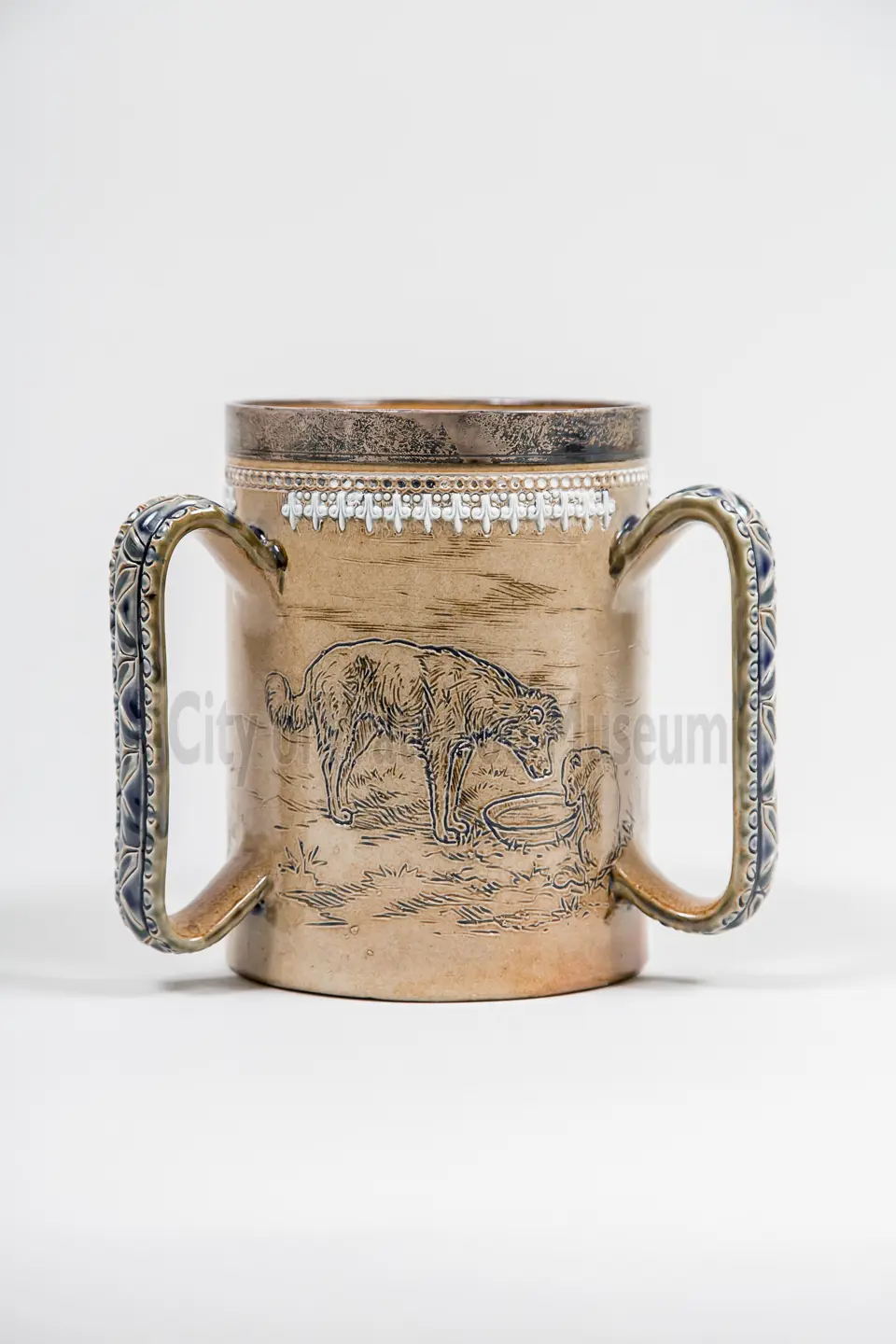 Loving Cup “Dog Cup” shows a dog eating from a bowl on the face of the mug