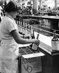 Liner worker girl filling bottles in the factory