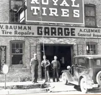 Image of three men standing before tire repair garage