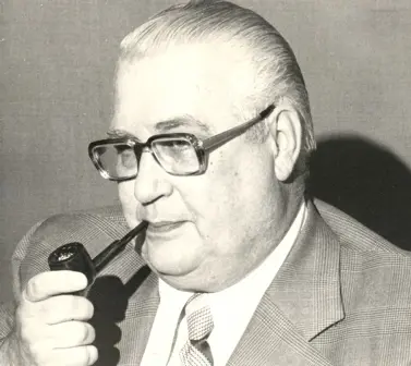 Black and white image of older man smoking pipe