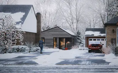 One-storey coach house with a pitched roof, located behind a detached home in a residential neighbourhood.