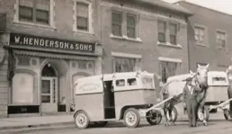 Black and white photo of two horse-drawn buggies and deliveryman outside Henderson's bakery.